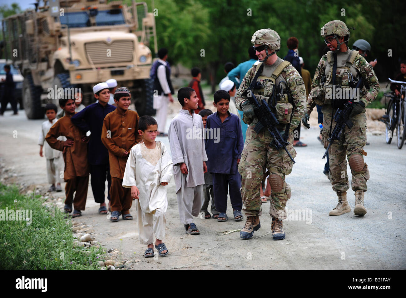 Stati Uniti Air Force Capt. Hans Winkler e 1Lt. Pettie Jasamine parlare ai bambini di Aprile 19, 2012, nella provincia di Laghman, Afghanistan. Il aviatori sono assegnati a Laghman Prevential Reconstruction Team dove contribuiscono a incrementare il governo locale infrastrutture nella provincia di Laghman. Winkler è assegnato al 633rd ingegnere civile squadrone a base comune Langley-Eustis, Virginia, e Pettie è assegnato al del sessantesimo ingegnere civile squadrone a Travis Air Force Base in California Tech. Sgt. DeNoris A. Mickle Foto Stock