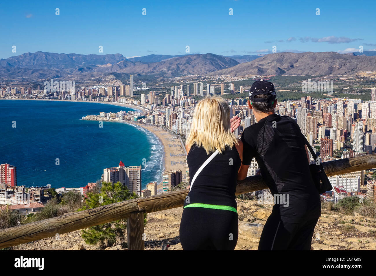 I turisti di indossare abbigliamento sportivo ammirando la vista di  Benidorm, Costa Blanca, Spagna. Preso da chiudere dietro di loro Foto stock  - Alamy