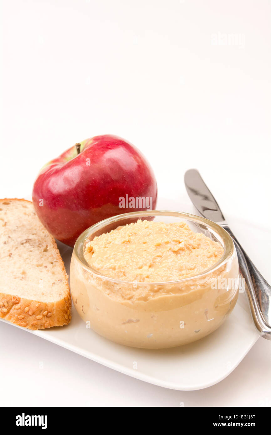 Un apple, fetta di pane e un piatto di burro di arachidi verticale con camera di testo Foto Stock