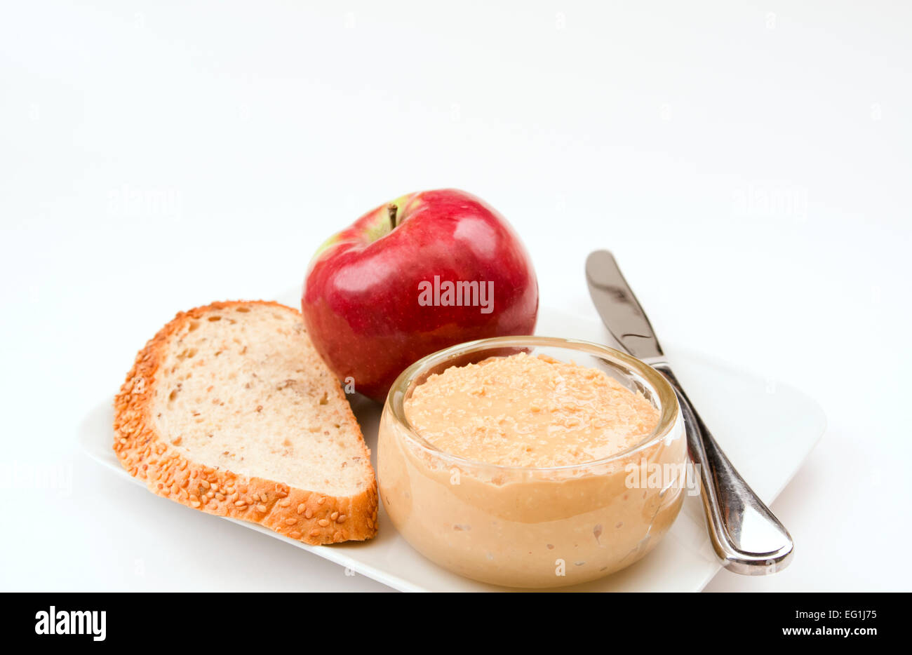 Un apple, fetta di pane e un piatto di burro di arachidi Foto Stock