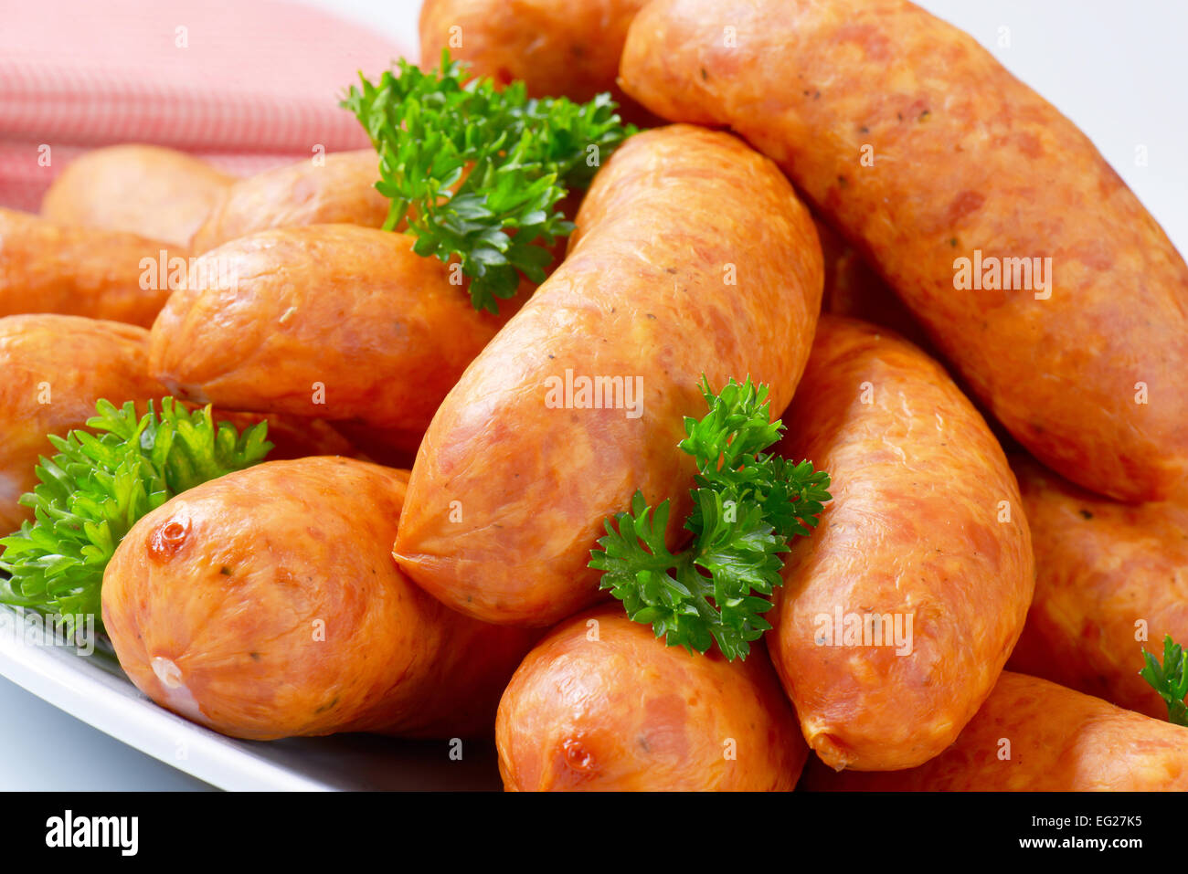 Pila di breve kielbasa salsicce su piastra Foto Stock