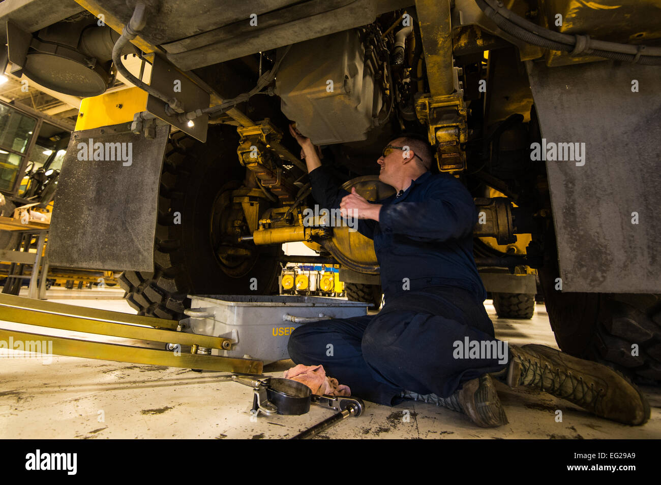 Senior Airman Antonio Tavares, 354disponibilità logistica Squadron veicolo manutentore, cambia l'olio su una neve flightline scopa Eielson Air Force Base in Alaska, e il Agosto 4, 2014. 354LRS è responsabile per la gestione e la manutenzione del veicolo governo flotta che incorpora una vasta e variegata flotta di neve in aggiunta a tutte le merci, passeggeri e merci di uso domestico movimenti per Eielson AFB. Il personale Sgt. Stephany Richards Foto Stock