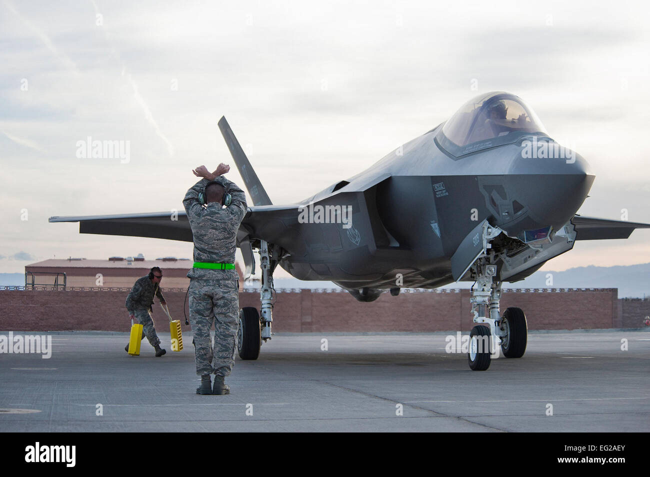 Equipaggio capi dal 57th ala Lightning aeromobile unità di manutenzione effettuare il marshalling di un F-35 Lighting II, 6 marzo 2013, presso la Base Aerea Militare di Nellis Nev. I primi due aeromobili sarà assegnato al 422d Test e valutazione Squadron. Lawrence Crespo Foto Stock