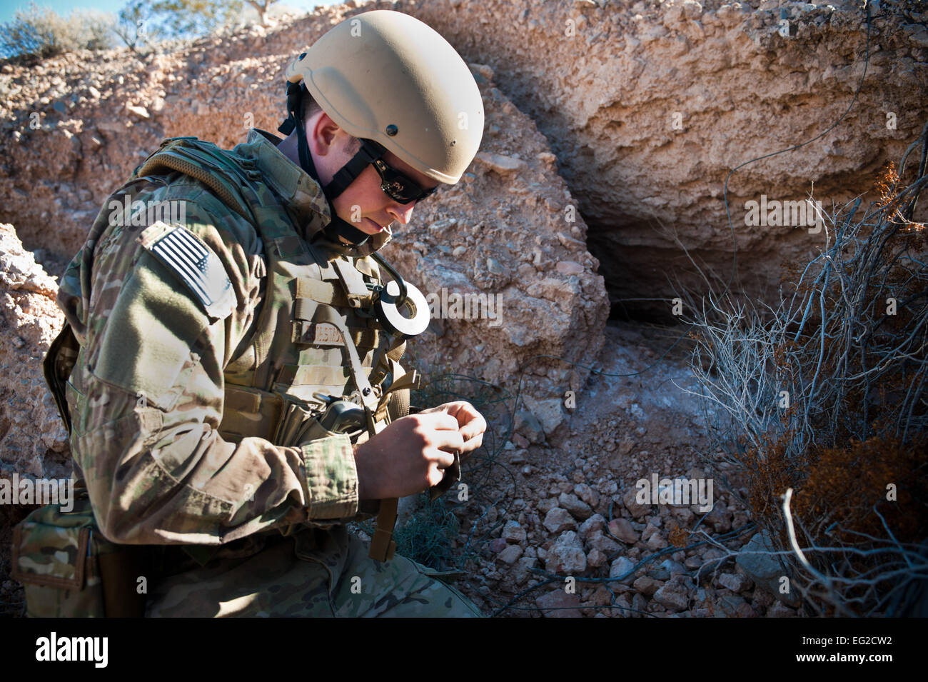 Stati Uniti Air Force Staff Sgt. Daniel Esselstrom, 23 Ingegneria civile Squadron l'eliminazione degli ordigni esplosivi tecnico dal Moody Air Force Base, si prepara a impostare una carica durante un eod contro-improvvisato dispositivo esplosivo corso di formazione il 12 dic. 2013, a Nellis AFB, Nev. Le operazioni in corso fornito ri-creazioni del passato la vita reale di incidenti. Airman 1. Classe Christopher Tam Foto Stock