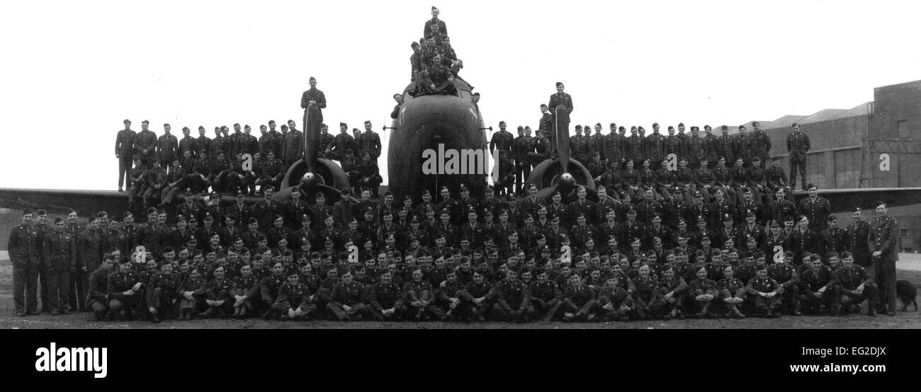 Membri della trentasettesima Troop Carrier Squadron si sono riuniti per una foto di gruppo nella parte anteriore di un Douglas C-47 Skytrain, designato Whiskey 7, sulla RAF Cottesmore, Inghilterra in 1944. La trentasettesima Airlift Squadron ricreato le foto storiche di onorare il loro squadrone di origine. Foto Stock