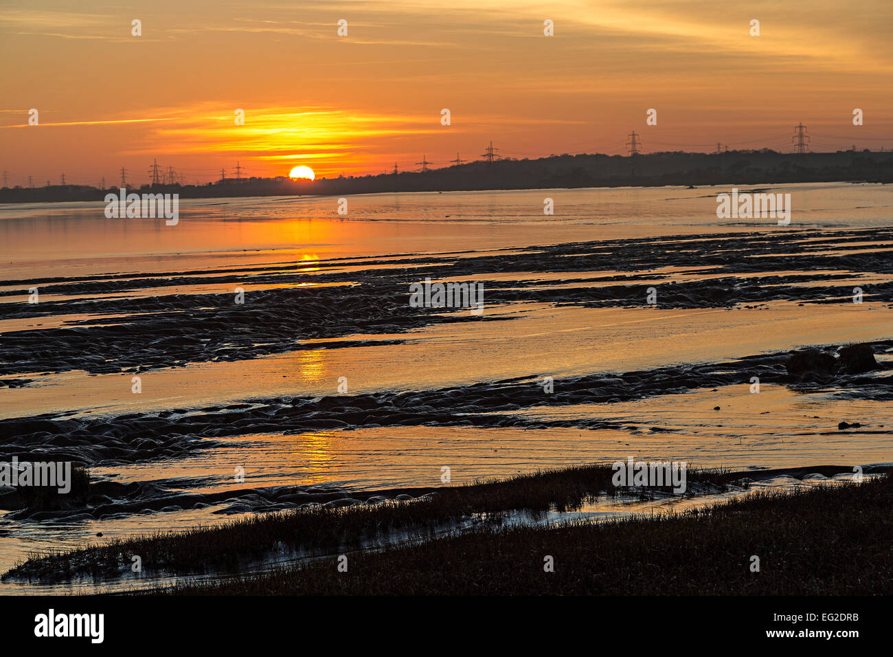 Il tramonto del fango appartamenti a bassa marea, punto Beachley, fiume Severn, Gloucestershire, England, Regno Unito Foto Stock