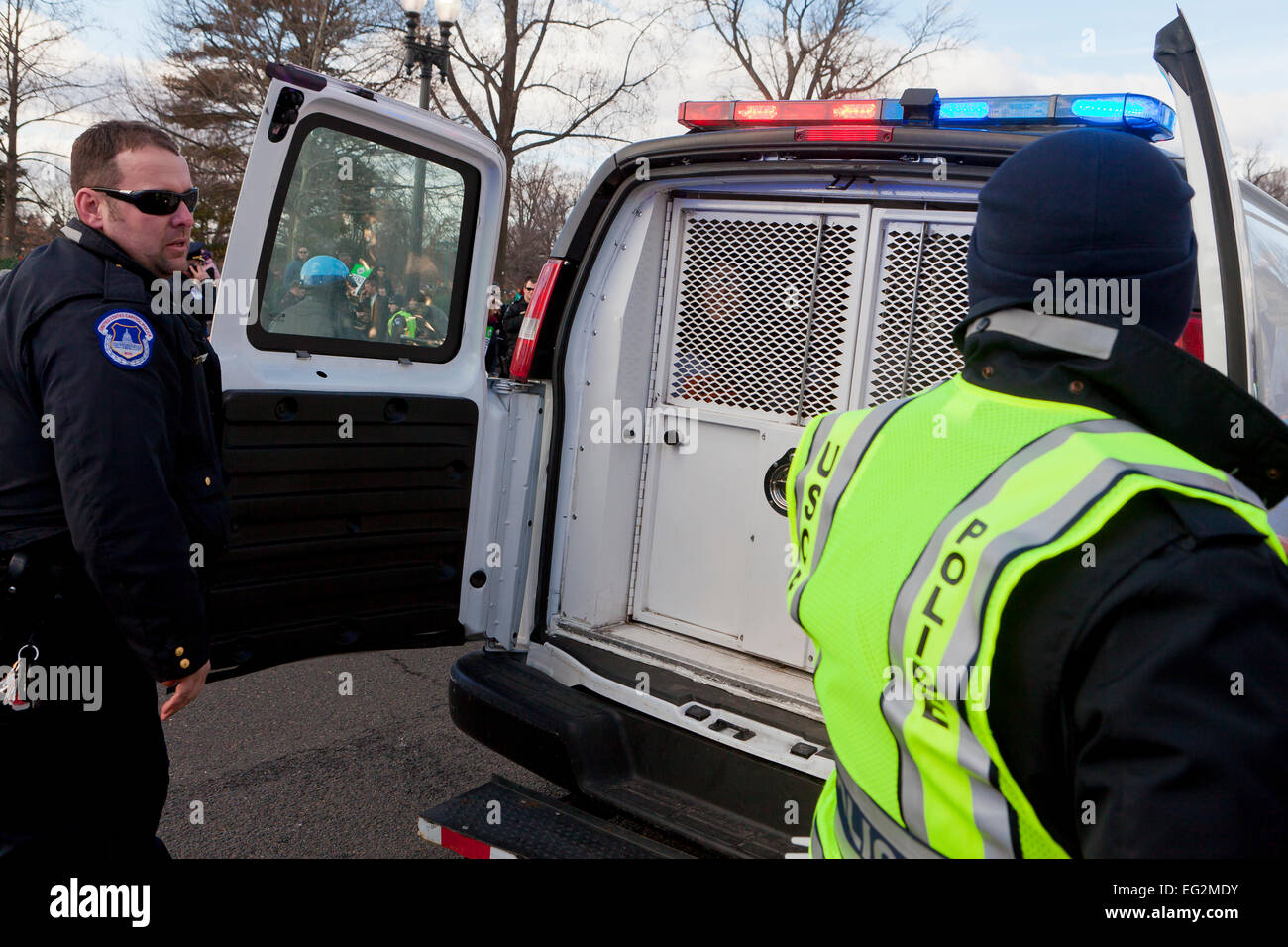 Gli ufficiali di polizia di polizia di chiusura van porte ad una strada manifestazione di protesta - Washington DC, Stati Uniti d'America Foto Stock