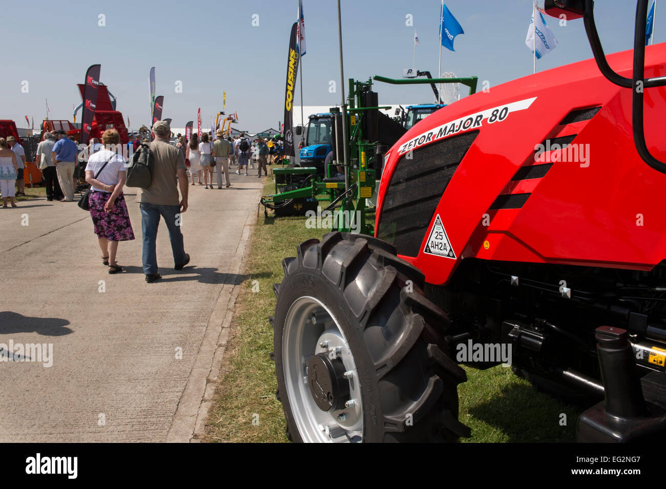 In una giornata di sole con il cielo blu, il gran numero di persone a piedi verso il basso occupato avenue, foderato con macchine agricole - Grande spettacolo dello Yorkshire, Harrogate, Inghilterra, Regno Unito. Foto Stock