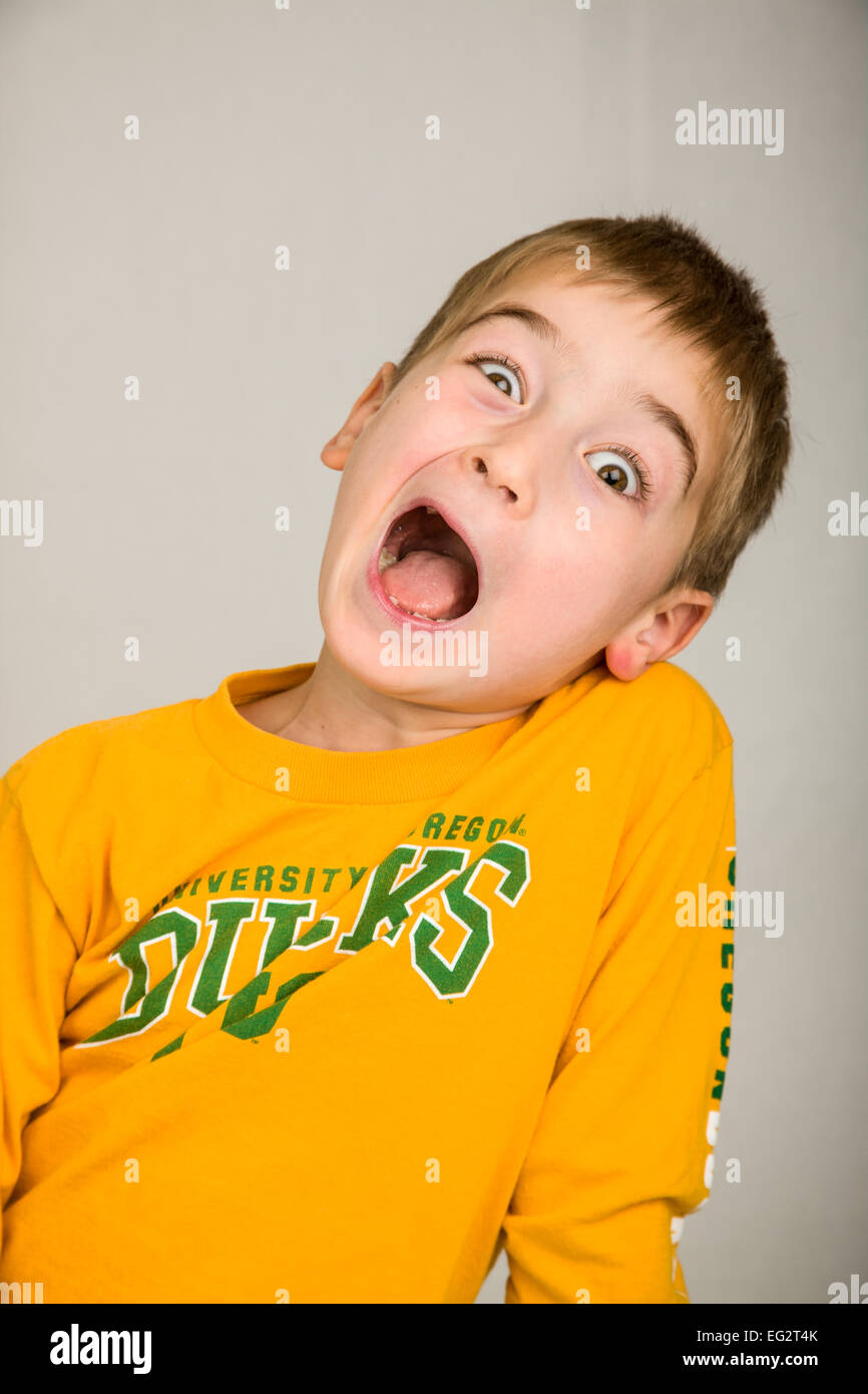 6 anno vecchio ragazzo deliberando sciocco e facendo una faccia buffa Foto Stock