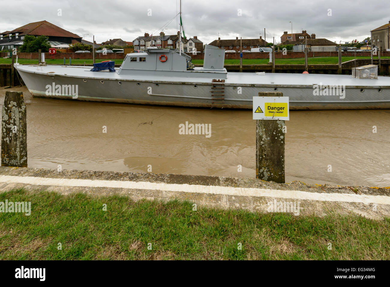 Vista di una grande barca arenarsi a bassa marea al terrapieno del porto fluviale presso il villaggio storico di segala, East Sussex Foto Stock