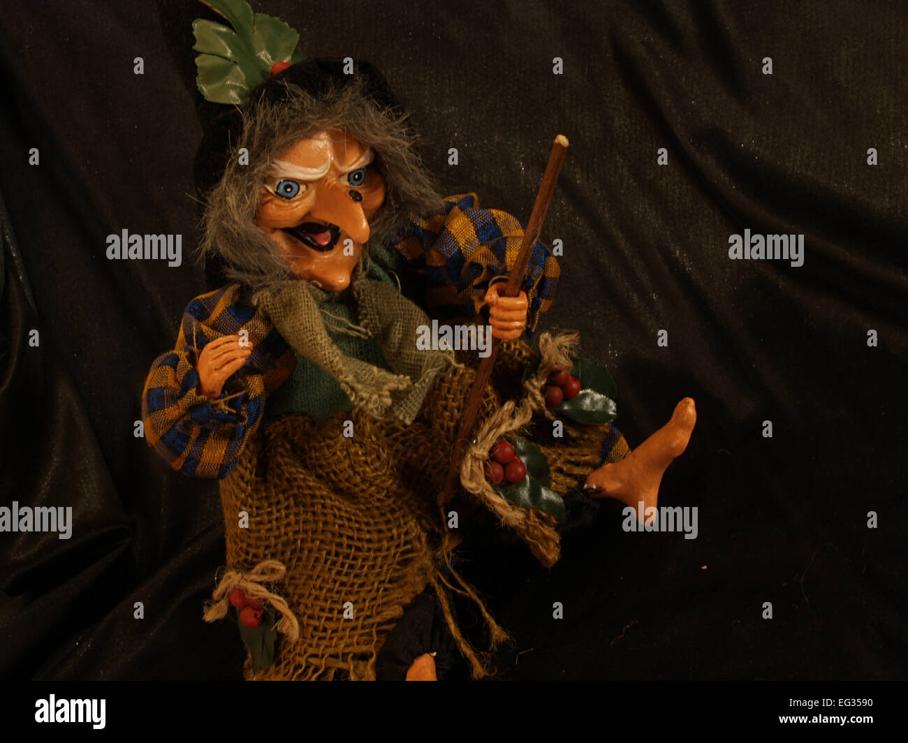 Strega bambola con una scopa su sfondo nero Foto Stock