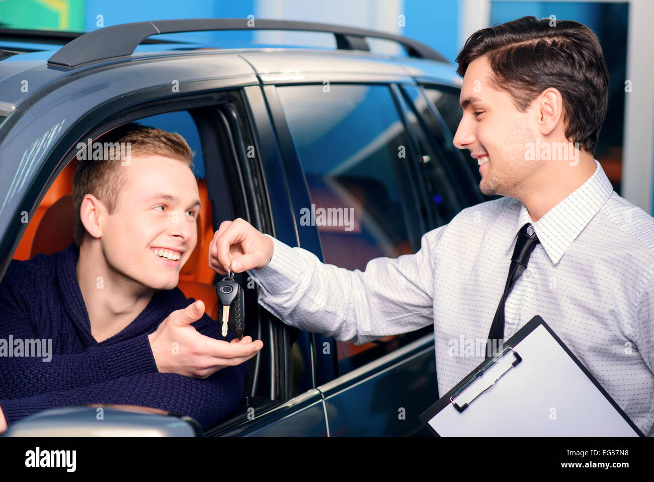 Sales Manager dando la chiave dalla nuova vettura Foto Stock