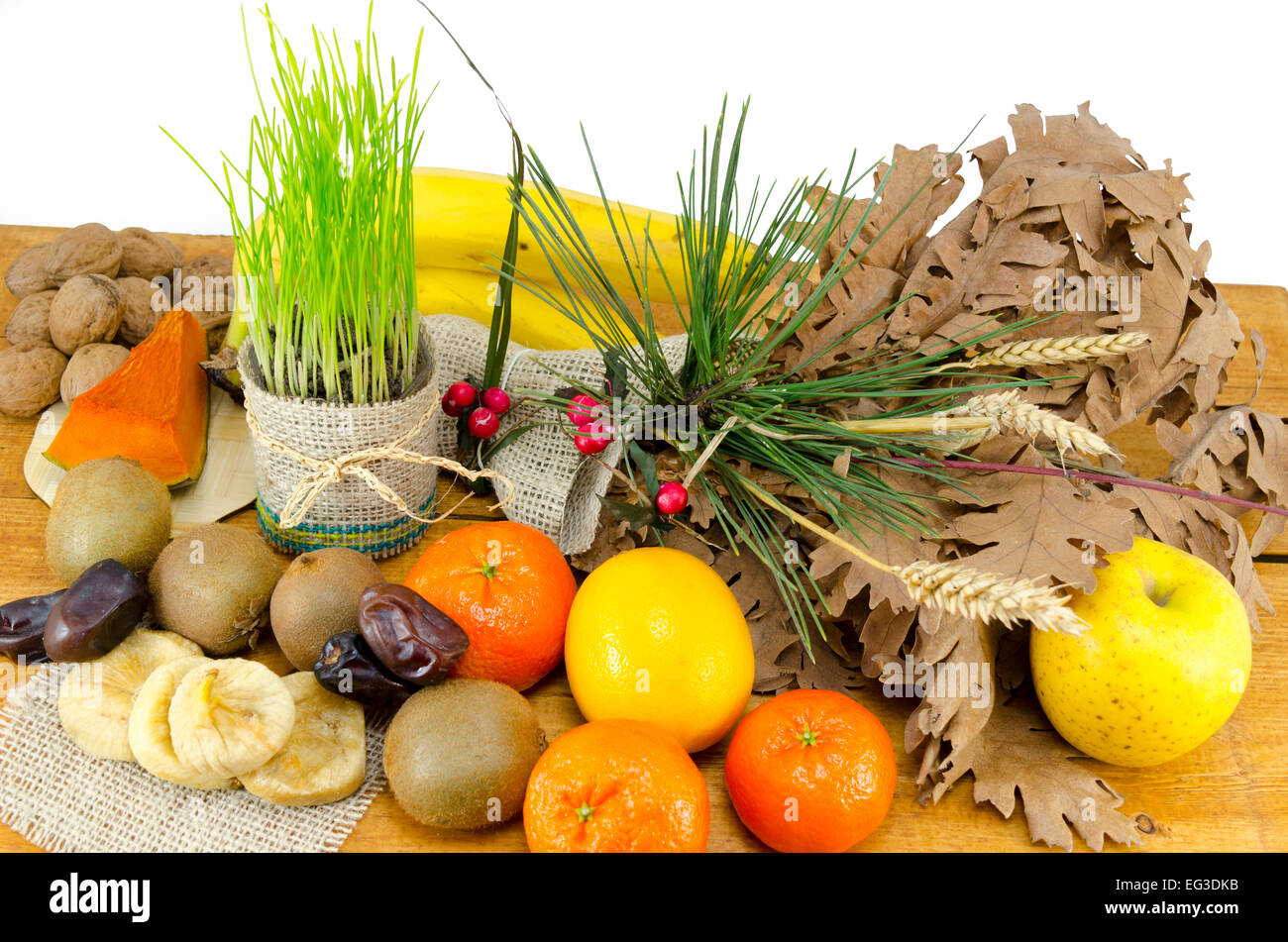 Ricca la vigilia di Natale offerte incluse varie essiccato e frutta fresca, grano verde e le noci su di un tavolo di legno, isolato, Foto Stock