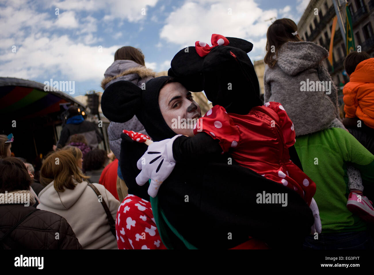 Barcellona, Spagna. 15 Feb, 2015. Un uomo vestito come Mickey Mouse tenendo premuto fino a sua figlia durante la Taronjada, una festa di carnevale che si svolge a Barcellona. Credito: Jordi Boixareu/Alamy Live News Foto Stock