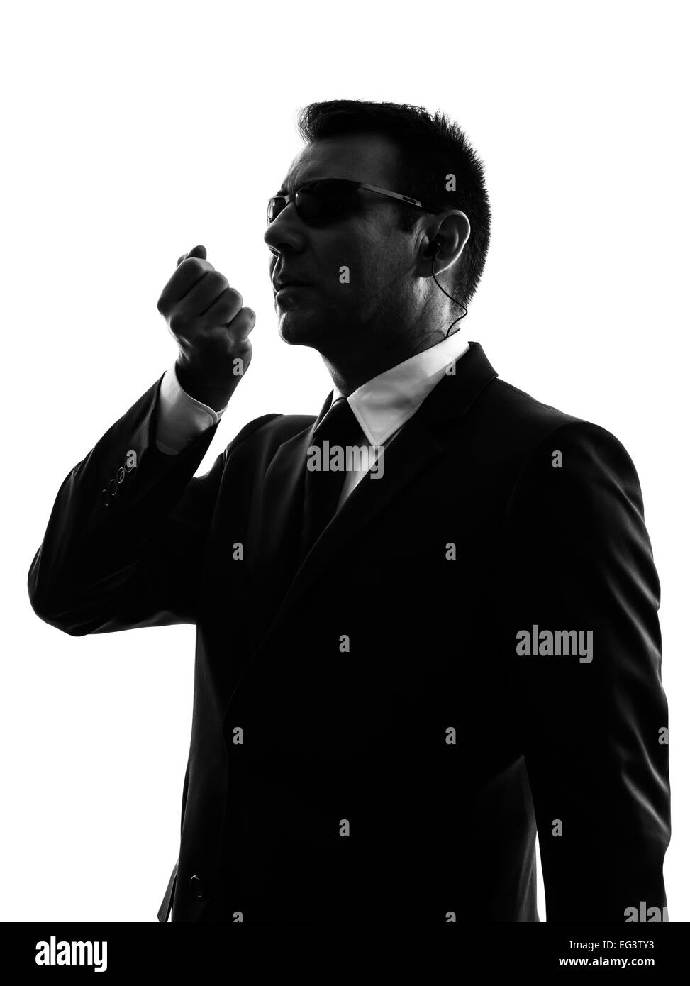 Un servizio segreto bodyguard security agent man in silhouette su sfondo bianco Foto Stock