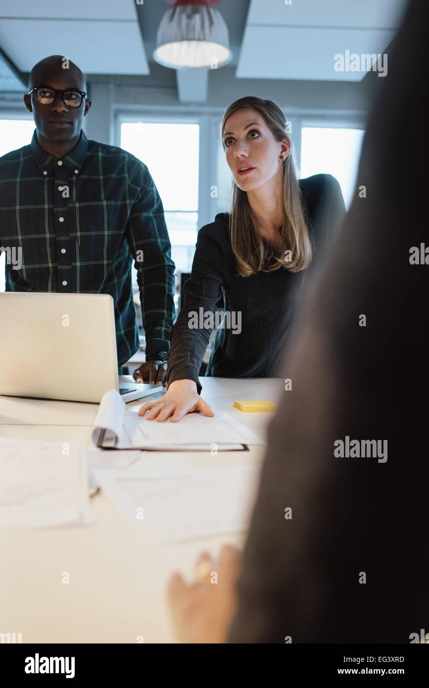 Imprenditrice lavorando su nuove idee. Giovane donna che mostra la nuova proposta commerciale per i colleghi durante una riunione in ufficio Foto Stock