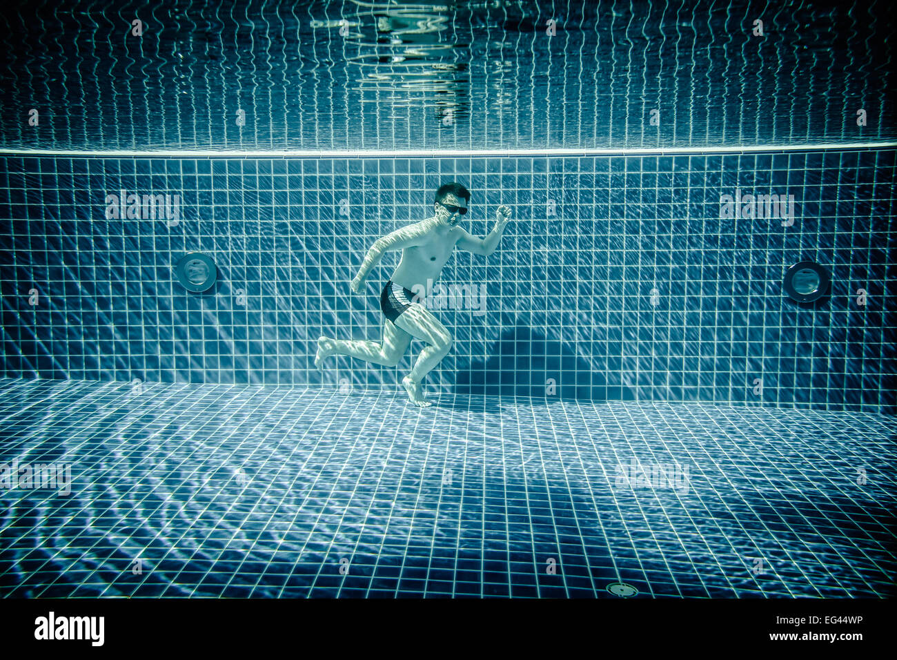 L'uomo sotto l'acqua scorre lungo il fondo di una piscina Foto Stock