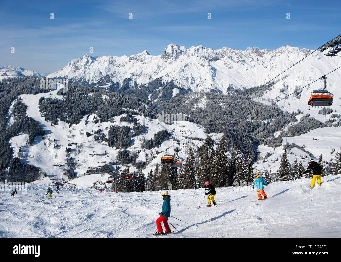 Sciatori sul pendio di fronte montagne, vista dell'Steinernes Meer, stazione sciistica Ski Amade, Dienten, Stato di Salisburgo, Austria Foto Stock