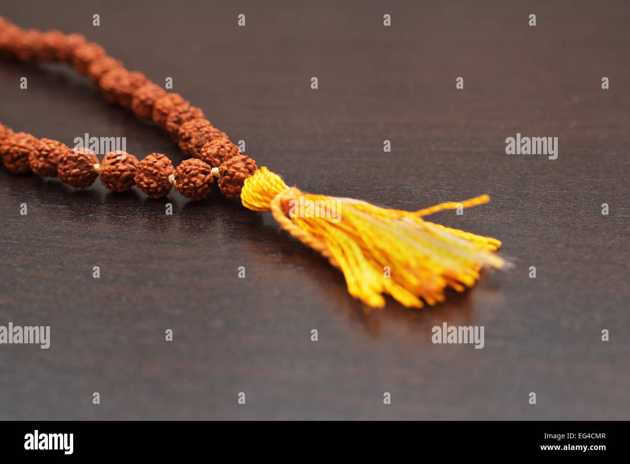 Japa mala sul tavolo. Preghiera talloni realizzati dai semi dell'albero rudraksha Foto Stock