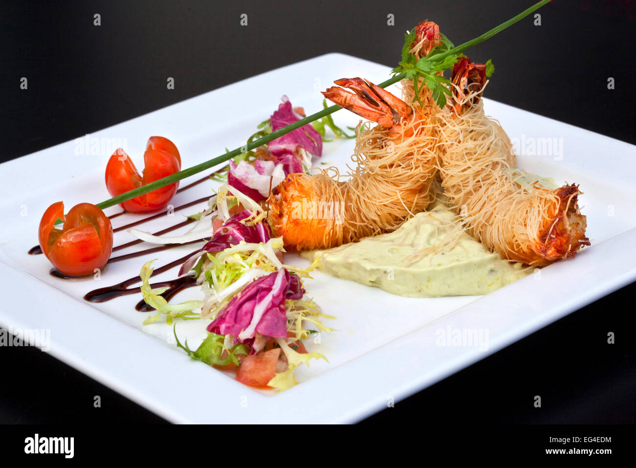 Gamberi fritti, Cinese vermicelli, guacamole e insalata su una piastra Foto Stock