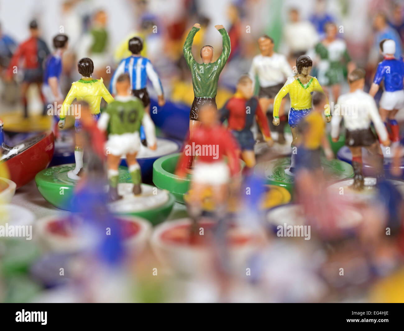 In piedi fuori dalla folla - Subbuteo® gioco calcio portiere circondato da giocatori provenienti da diversi team Foto Stock