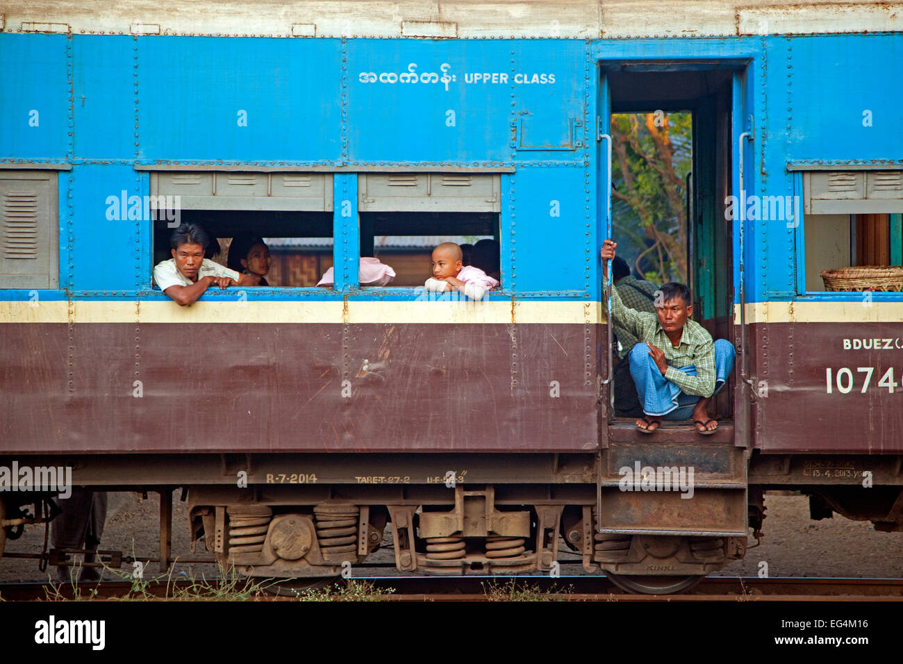 Passeggeri birmano in blu di classe superiore di trasporto passeggeri di un vecchio treno britannica in Myanmar / Birmania Foto Stock