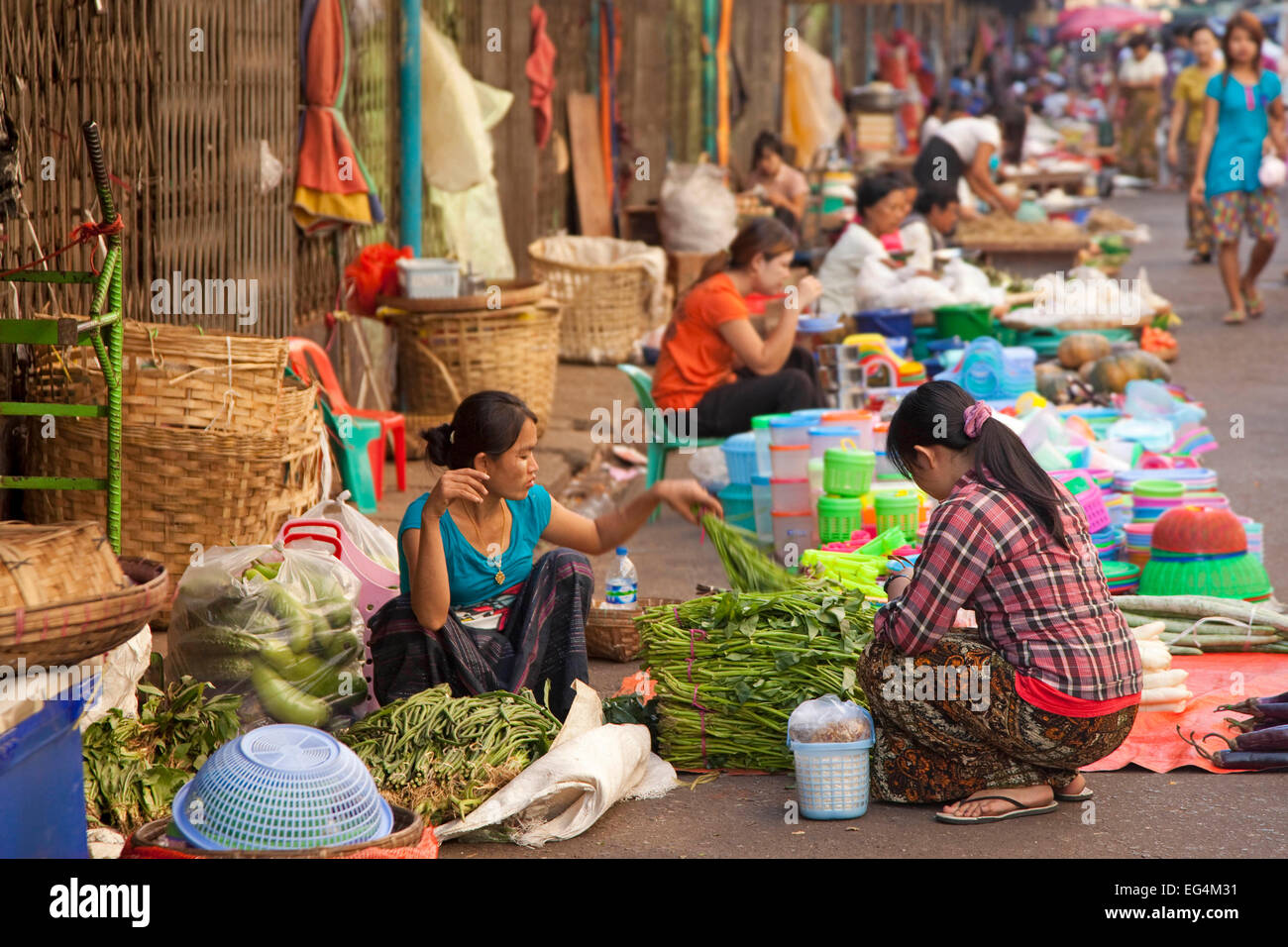 Femmina birmano venditori ambulanti che vendono alimenti e merci sul terreno al mercato di Yangon / Rangoon, Myanmar / Birmania Foto Stock