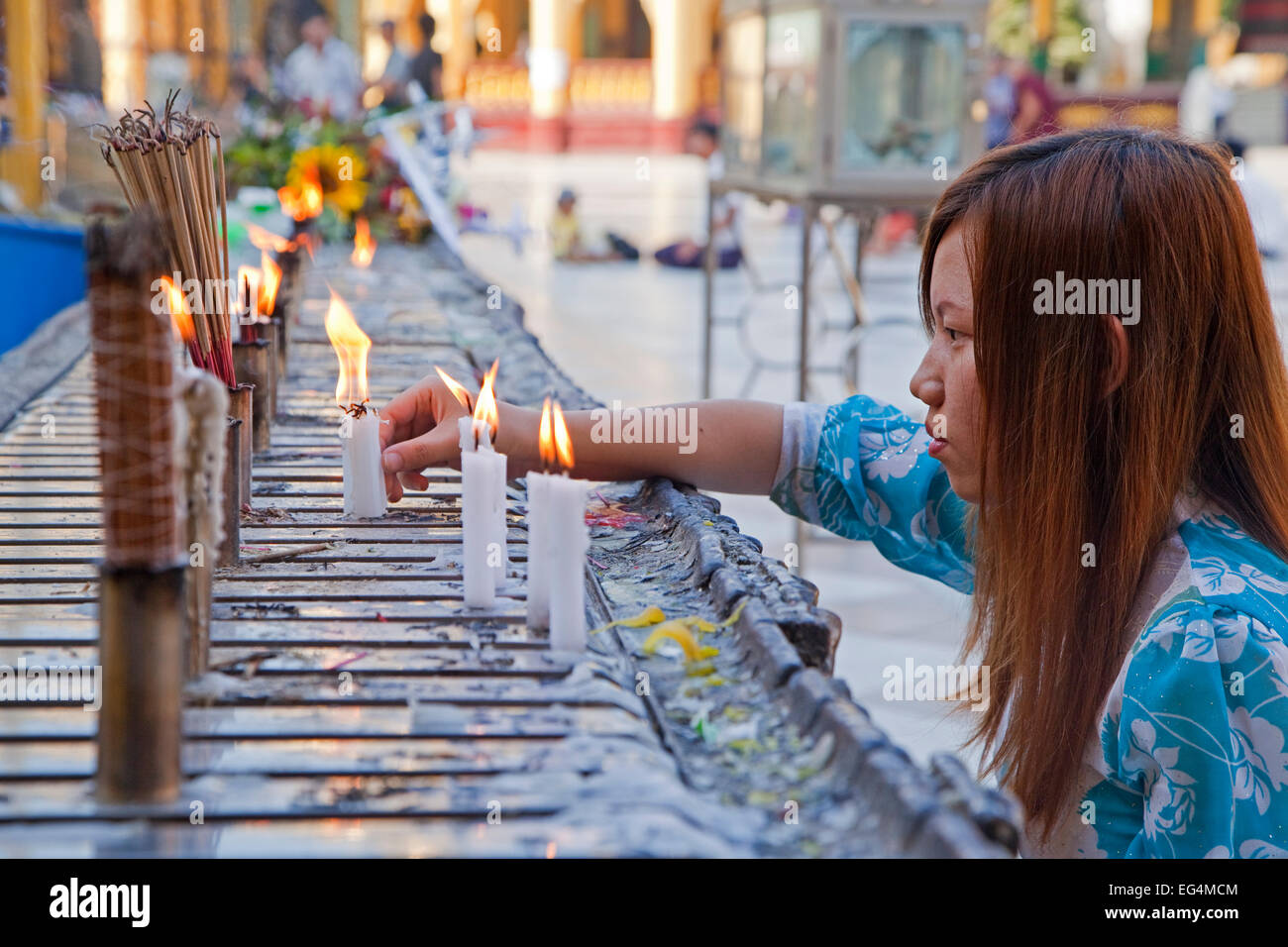 Ragazza birmano candele accese e bastoncini di incenso / joss bastoni in Zedi Shwedagon pagoda Daw a Yangon, Myanmar / Birmania Foto Stock