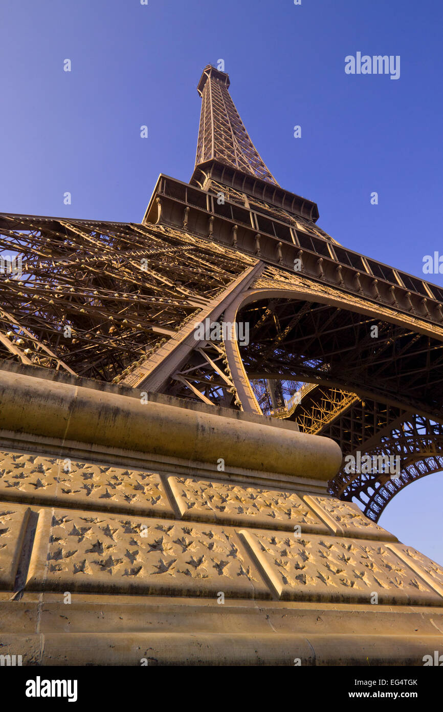 Guardando verso l'alto la torre Eiffel con le fondamenta in pietra in primo piano Foto Stock