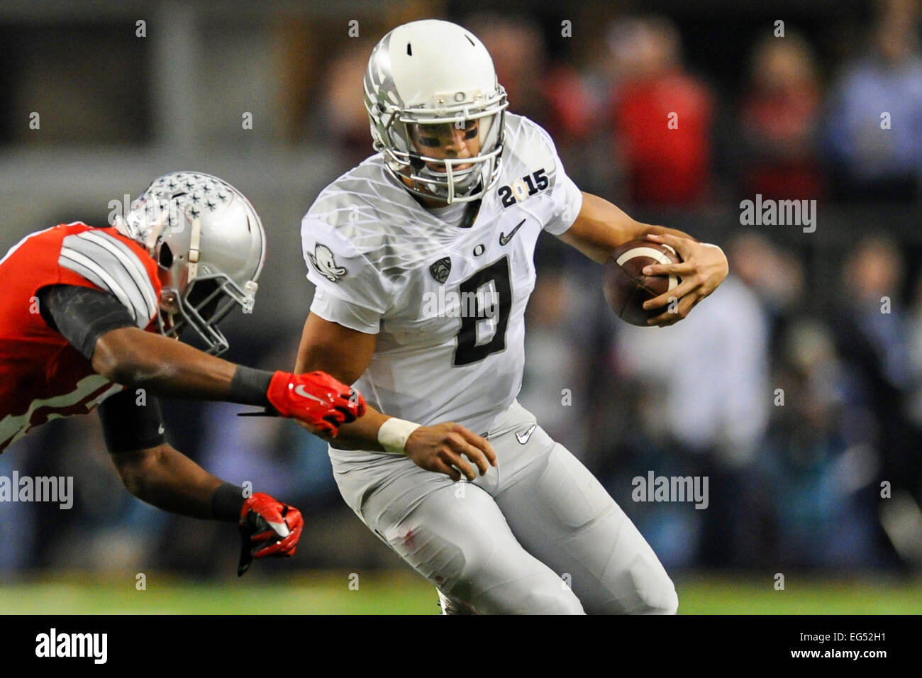 Oregon quarterback Marcus Mariota (8) è azionato fuori dai limiti da Ohio State cornerback Eli Apple (13) durante il secondo trimestre del College Football Playoff campionato nazionale di AT&T Stadium Lunedì, Gennaio 12, 2015, in Arlington, Texas. Foto Stock