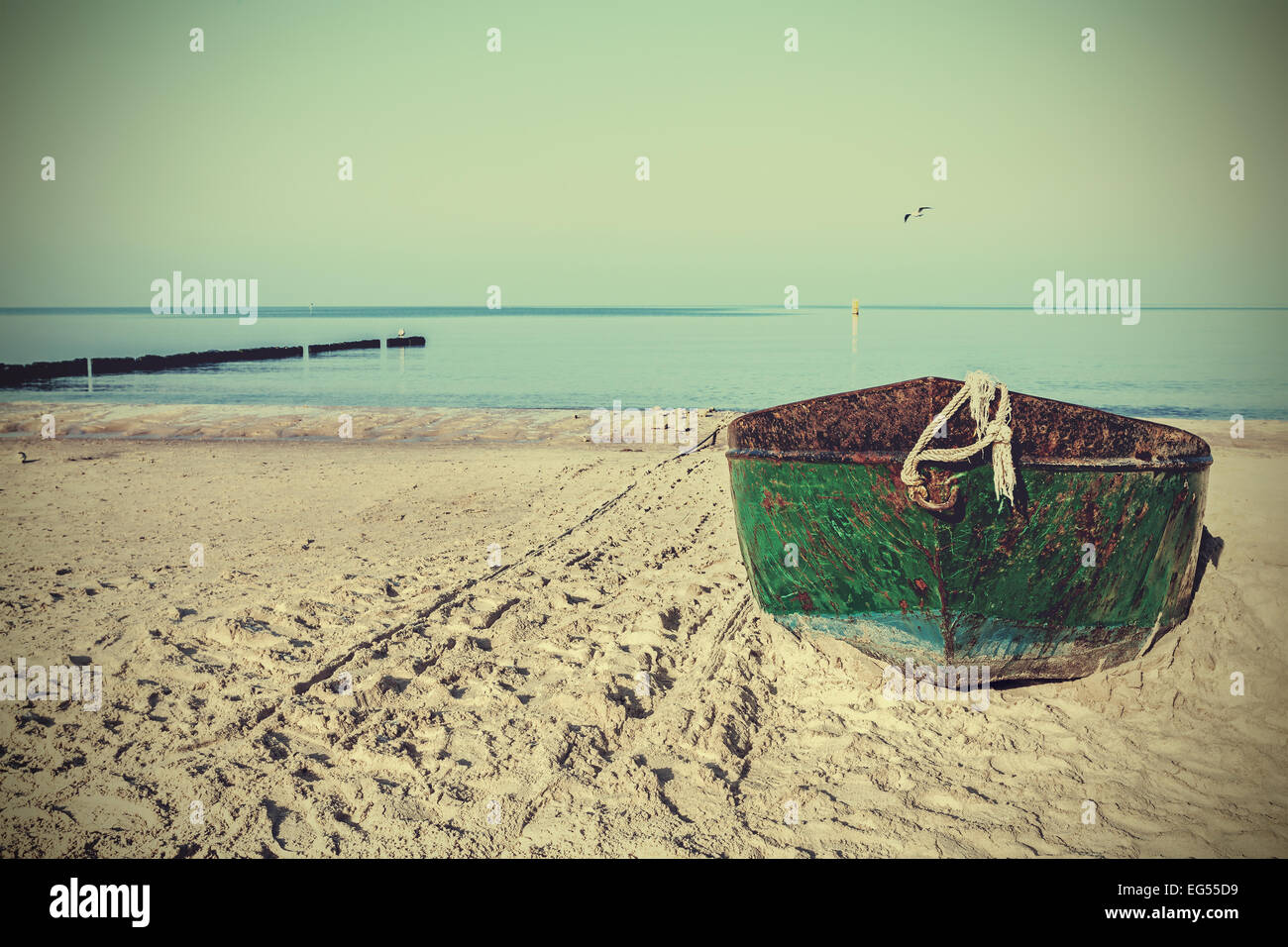 Retrò immagine filtrata di un vecchio acciaio arrugginito barca sulla spiaggia. Foto Stock