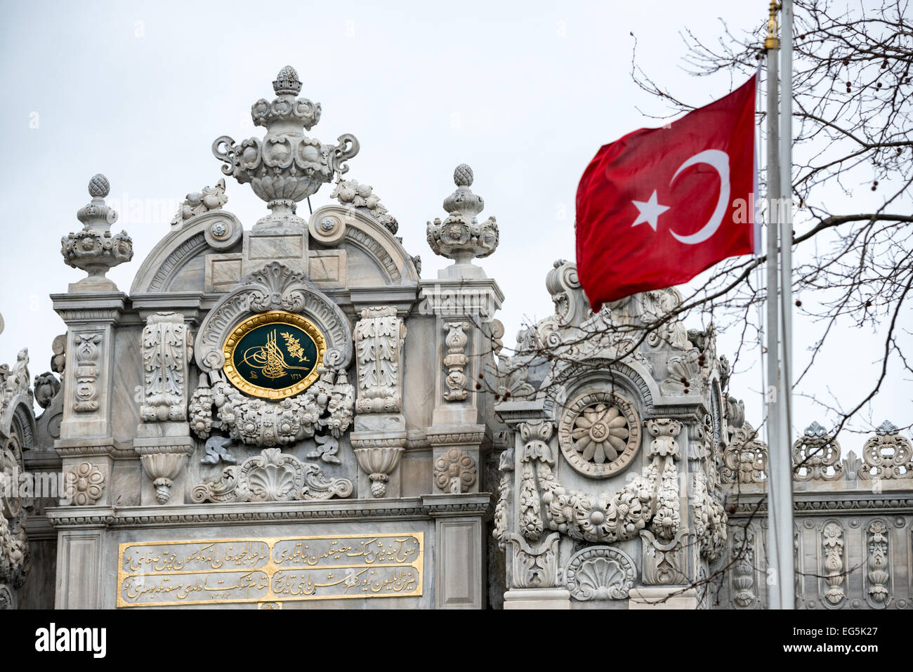 Porta del Palazzo Dolmabahe bandiera turca Istanbul // ISTANBUL, Turchia - Una bandiera turca vola di fronte al cancello principale del Palazzo Dolmabahce. Il Palazzo Dolmabahce, sulle rive dello stretto del Bosforo, fu il centro amministrativo dell'Impero Ottomano dal 1856 al 1887 e dal 1909 al 1922. Costruito e decorato in stile barocco ottomano, si estende lungo una sezione della costa europea dello stretto del Bosforo nel centro di Istanbul. Foto Stock
