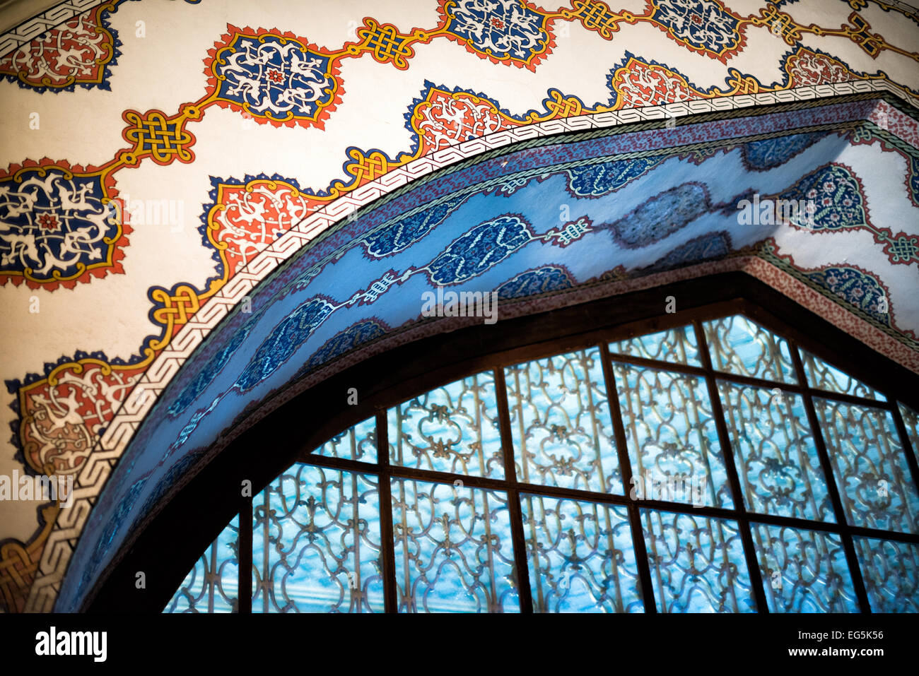 ISTANBUL, Turchia / Türkiye - decorazioni finemente dipinte circondano una finestra ad arco nella sala del Consiglio Imperiale del Palazzo Topkapi. Questa finestra dorata, accessibile attraverso la Torre di giustizia, ha avuto un significato simbolico importante nel governo ottomano. L'intricato schema decorativo riflette il significato della camera come luogo di incontro per i più alti funzionari dell'impero. Foto Stock