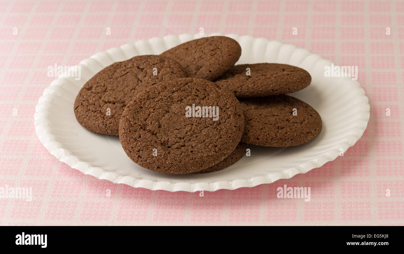 Biscotti al cioccolato su un piatto di carta in cima a un tavolo a scacchiera panno. Foto Stock