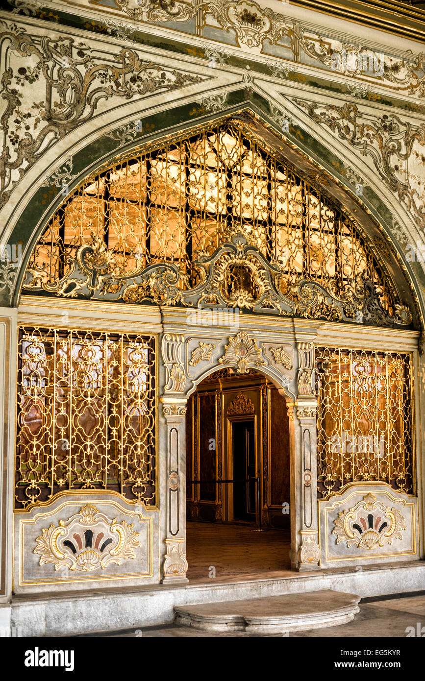 Ingresso della sala del Consiglio Imperiale del Palazzo Topkapi Istanbul // ISTANBUL, Turchia - ingresso decorato con decorazioni ornamentali e griglie dorate in ferro fuori dalla sala del Consiglio Imperiale nel Palazzo Topkapi. Questa camera servì come luogo di incontro per i più alti funzionari dell'Impero ottomano, tra cui il Gran Visir e i ministri del consiglio che formarono il Dîvân-ı Hümâyûn (Consiglio imperiale). La lavorazione decorativa in metallo esemplifica la raffinata maestria artigianale dell'architettura del palazzo ottomano. Il Palazzo Topkapi funzionò come residenza principale e sede amministrativa dei sultani ottomani dal XV al XIX secolo. Foto Stock
