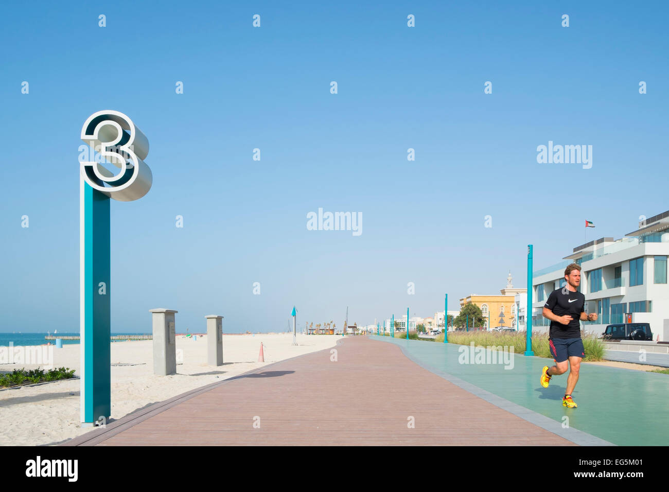 L'uomo jogging lungo nuovo ristrutturato il jogging e passeggiate via lungo la spiaggia di Umm Suqueim in Dubai Emirati Arabi Uniti Foto Stock