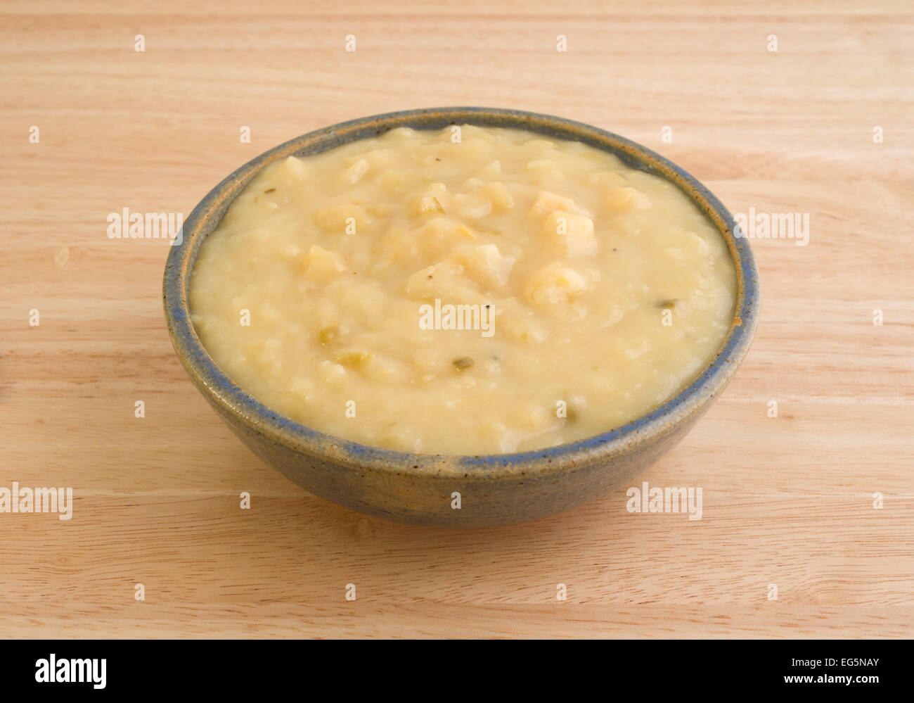 A che serve della fecola di patate e zuppa di porri in un vecchio recipiente di ceramica su una tavola di legno alto. Foto Stock