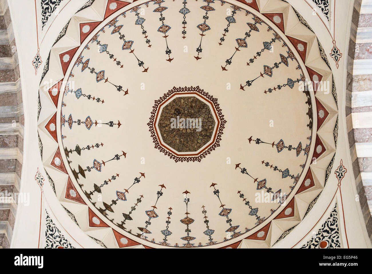 Moschea Suleymaniye Cupola dipinti Istanbul // ISTANBUL, Turchia - dipinti decorativi e calligrafia ornano le cupole interne della Moschea Suleymaniye. I disegni intricati combinano motivi geometrici, motivi floreali e calligrafia islamica nello stile ottomano classico. Completati nel 1558, questi elementi decorativi mostrano la raffinatezza artistica raggiunta durante il regno del sultano Solimano. Foto Stock