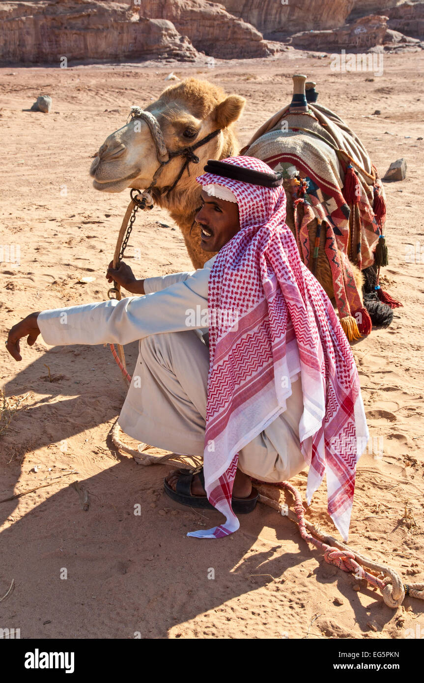 Il cammello e il beduino arabo in attesa per i turisti nel deserto paesaggio Foto Stock