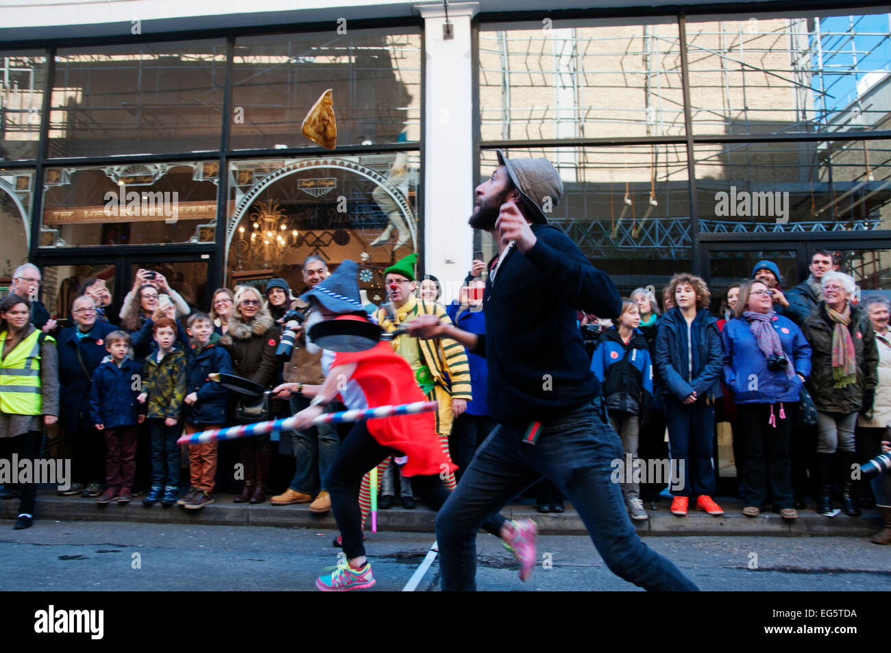 Martedì grasso pancake race,organizzato da arti alternative in aiuto di Londra Air Ambulance. Lanciare il pancake al traguardo Foto Stock