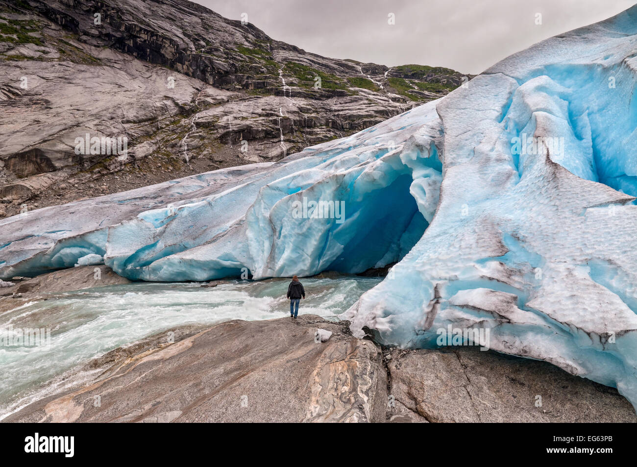 Jostedalsbreen ghiacciaio con il fiume glaciale e uomo in Norvegia - Fusione a causa del riscaldamento globale. Foto Stock