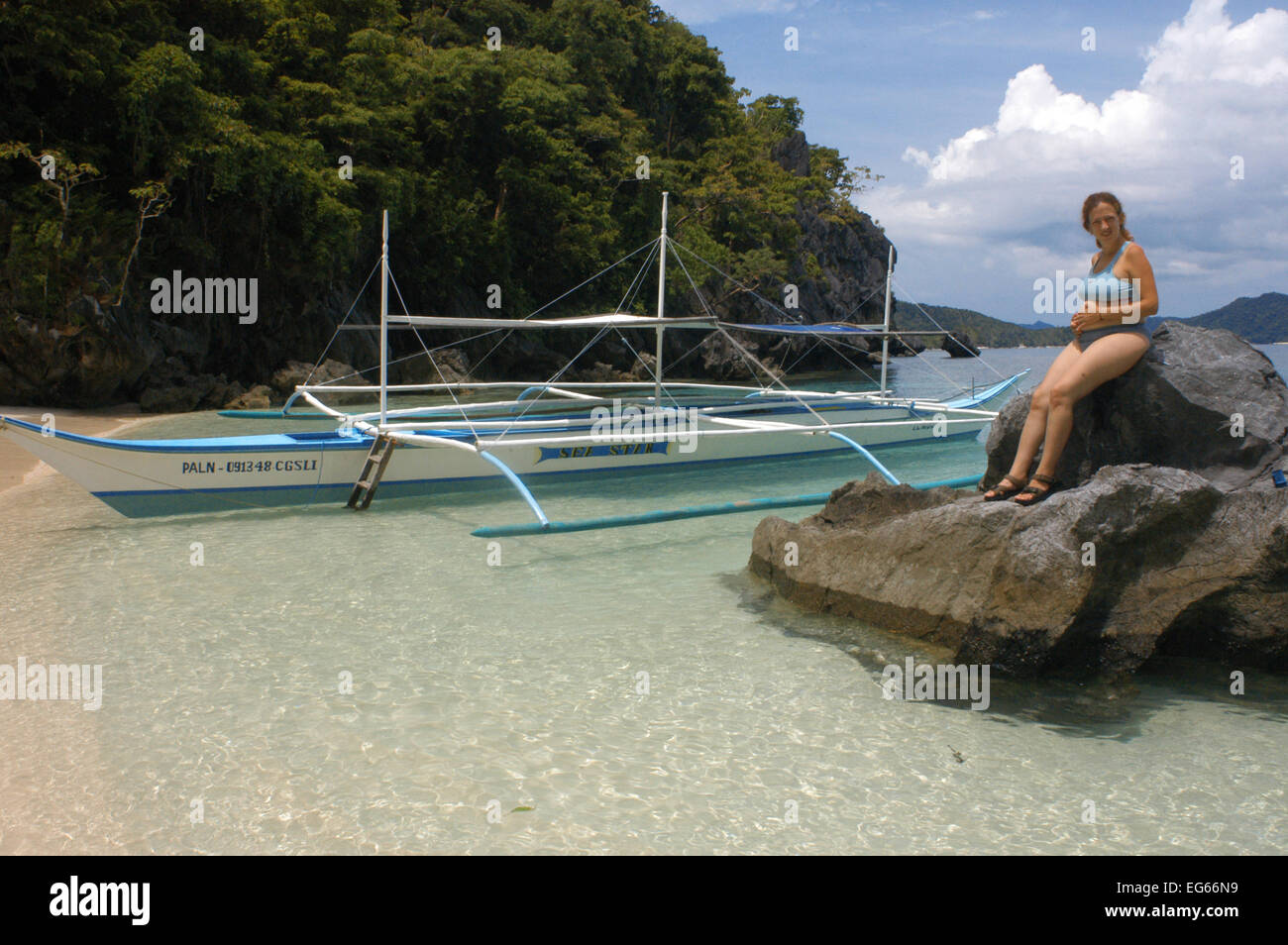 Barca di Bangka e la gravidanza di una donna turistica su una spiaggia. Cudugman isola. Arcipelago Bacuit. Palawan. El Nido. Filippine. El Nido Foto Stock