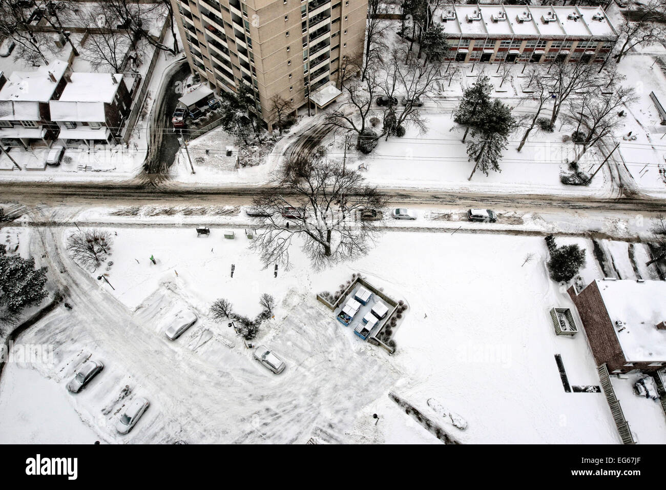 Angolo di alta vista della strada di città e case nella zona residenziale durante la nevicata Foto Stock