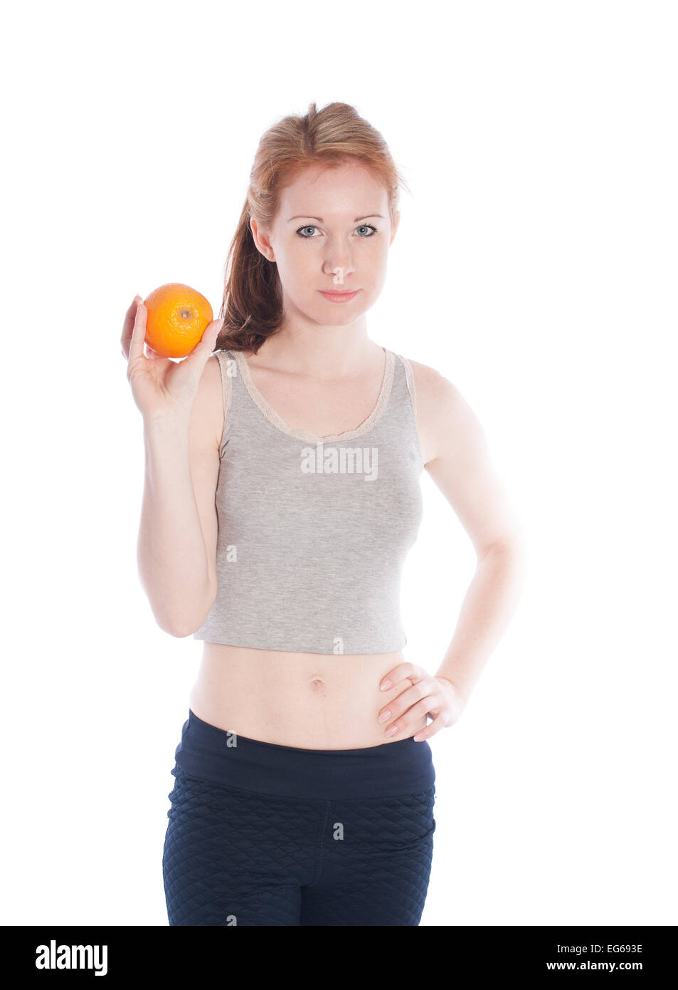 Athletic ragazza con orange in mani su uno sfondo bianco. Foto Stock