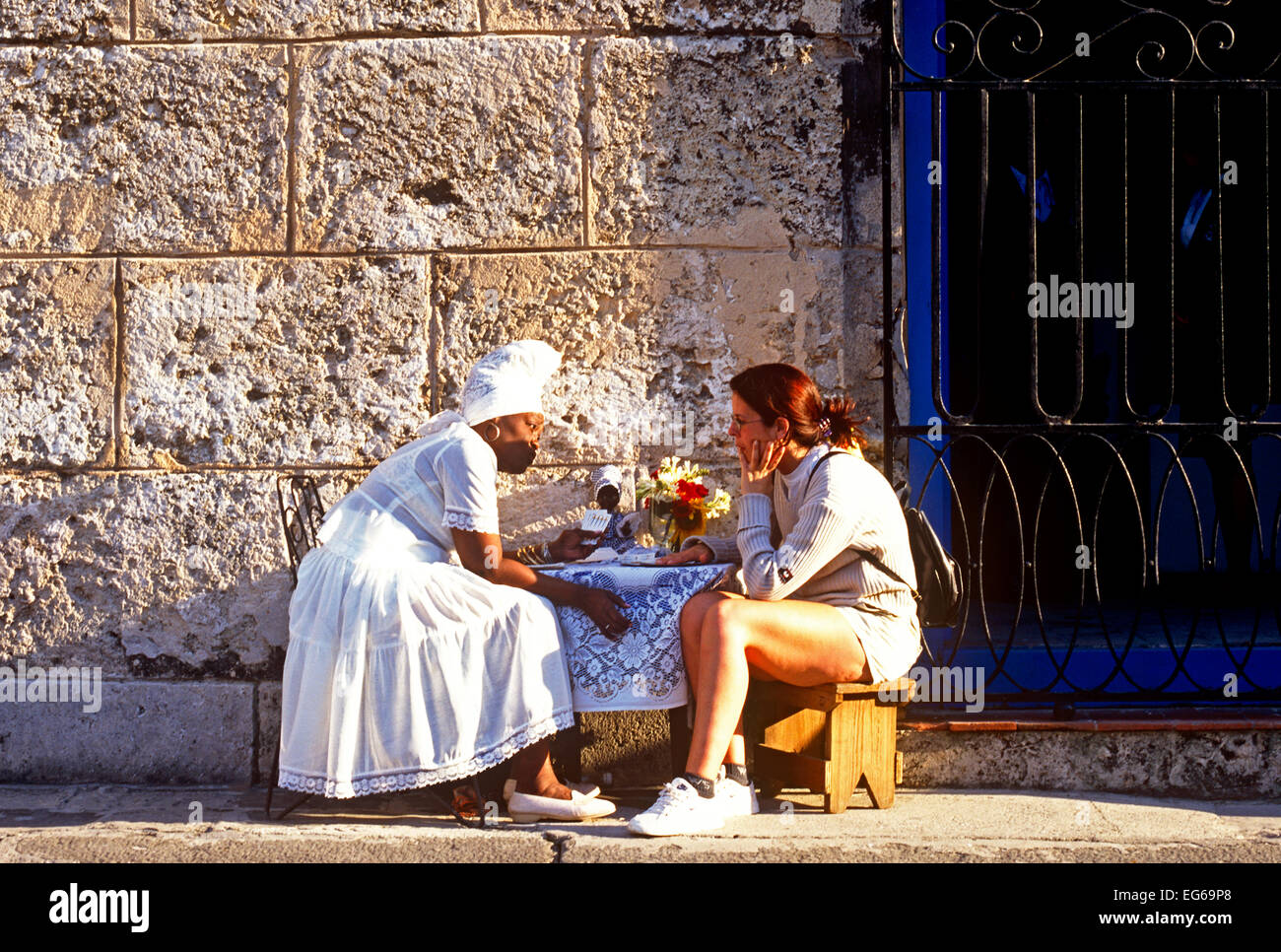 Voodoo Fortune Teller dando una lettura ad un turista in Havana Cuba Foto Stock