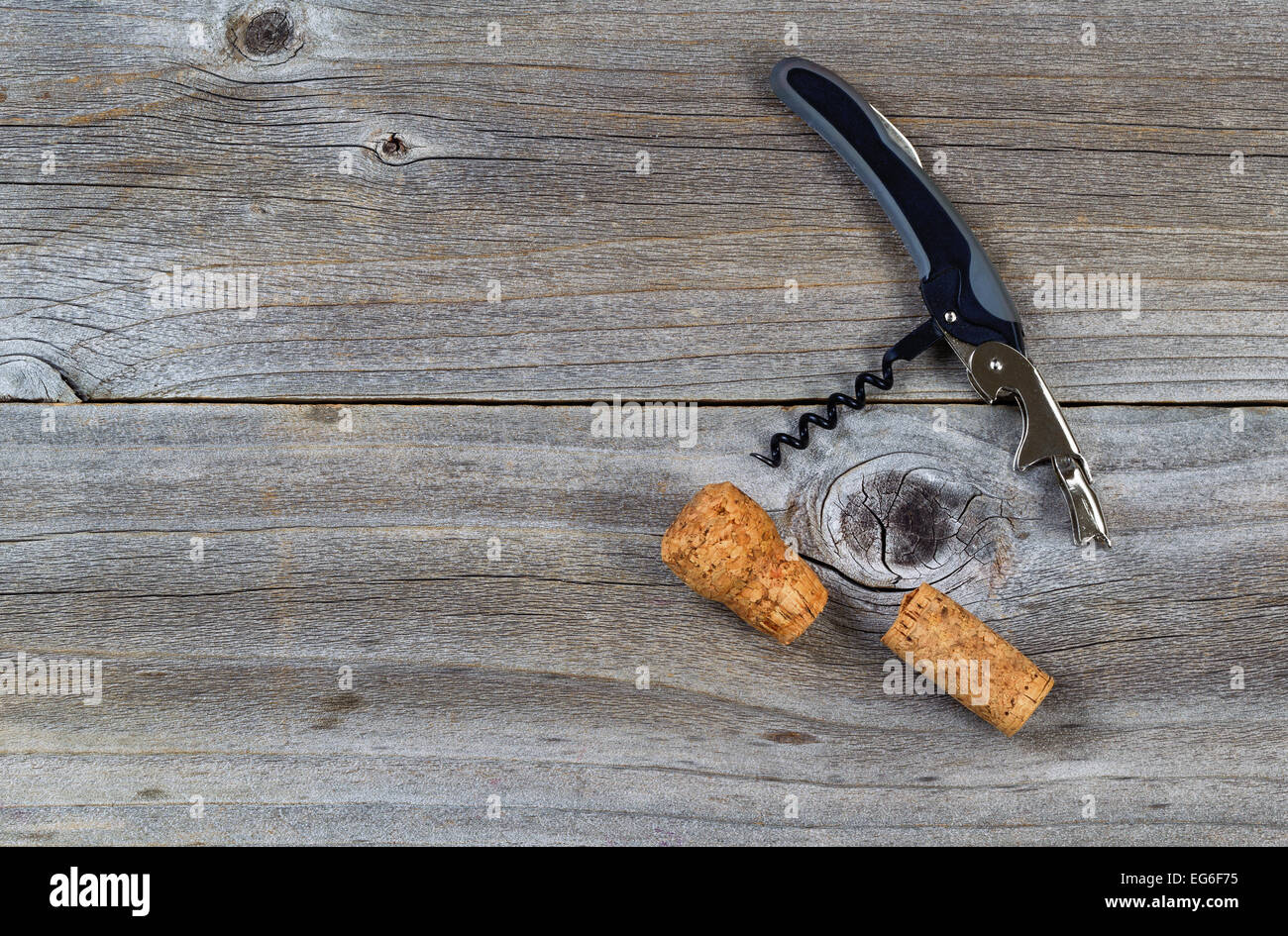 Vista dall'alto colpo angolato di vino apribottiglie con tappi di sughero su rustiche tavole in legno Foto Stock