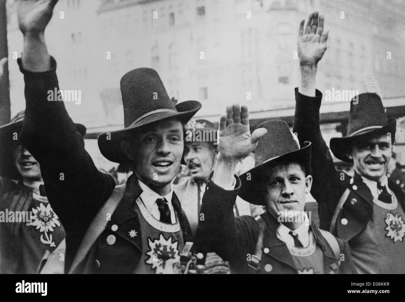Gli uomini in costume tirolese festeggiare il tedesco l'annessione dell'Austria con un saluto nazista. L'ideologia nazista innocentemente integrato Foto Stock