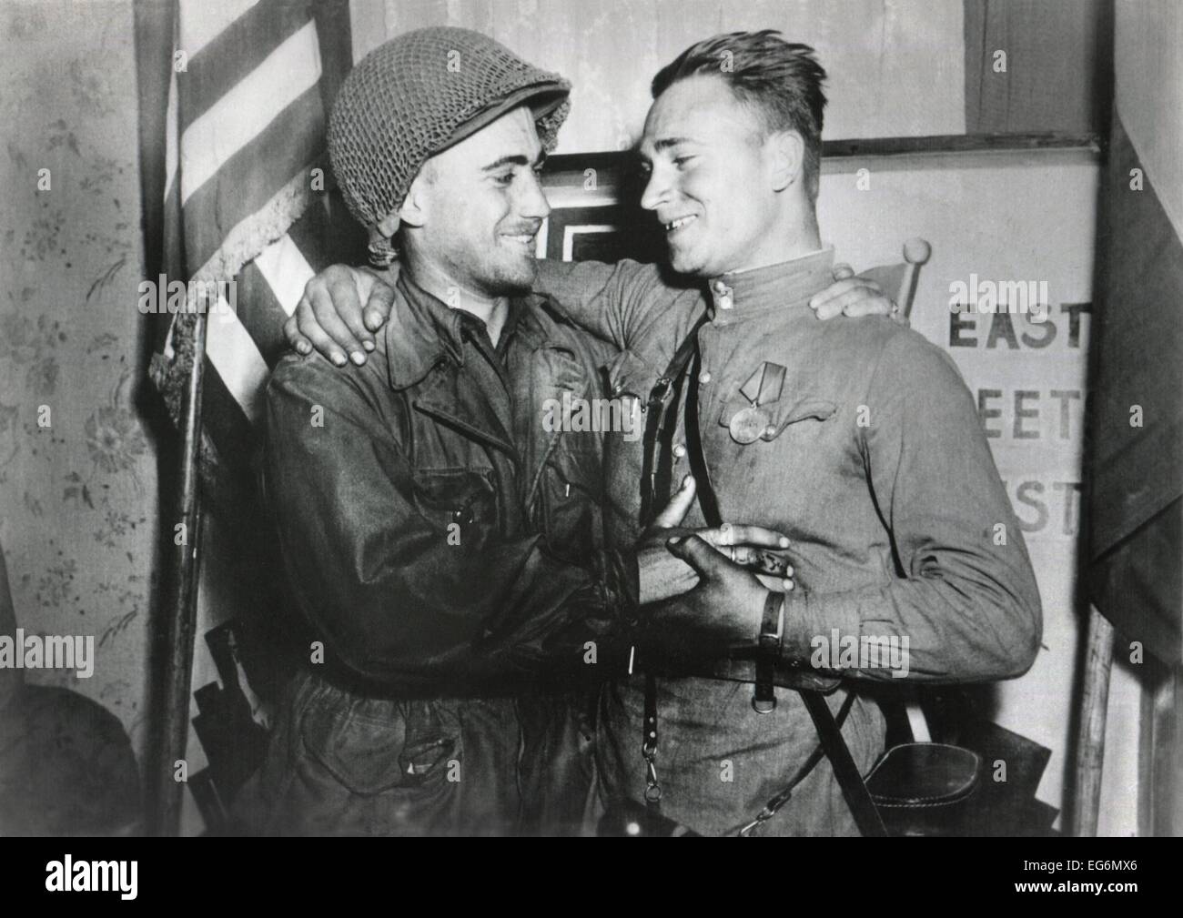 Stati Uniti Lt. William Robertson e sovietica Lt. Alexander Sylvashko abbraccio. Dietro di loro un segno, "l'Oriente incontra l'Occidente" per celebrare Foto Stock