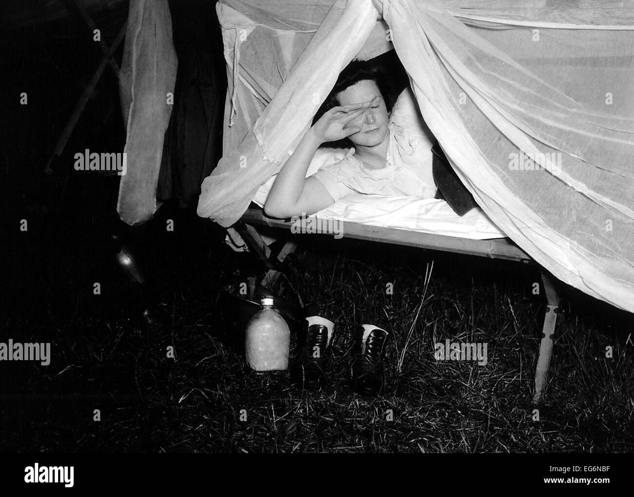 American WAC solleva la rete sopra il suo lettino come un fotografo il flash illumina la scena. Sul terreno sono la sua acqua Foto Stock