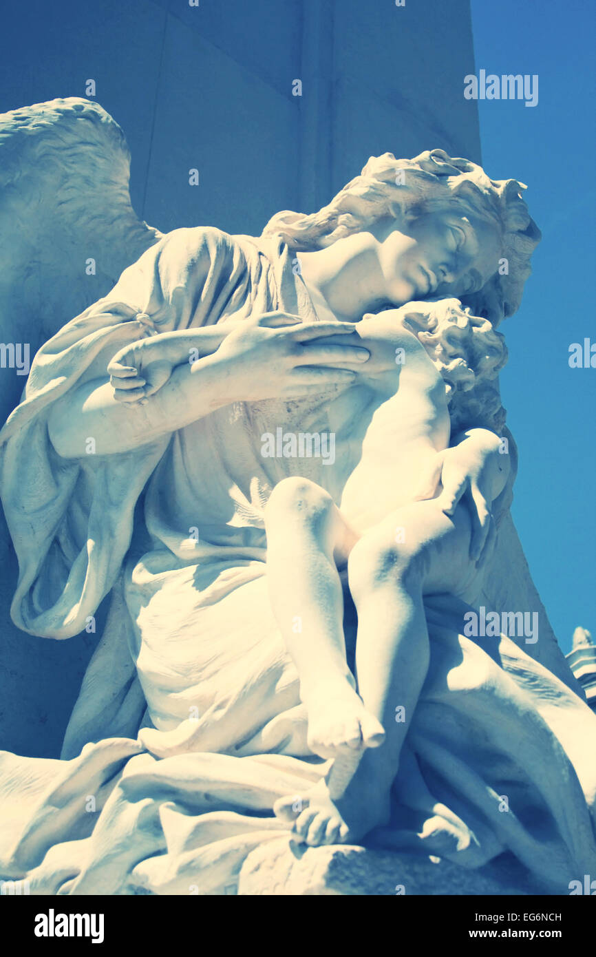 Statua di angelo e bambino sulla tomba. Primo cimitero di Atene, G Foto Stock
